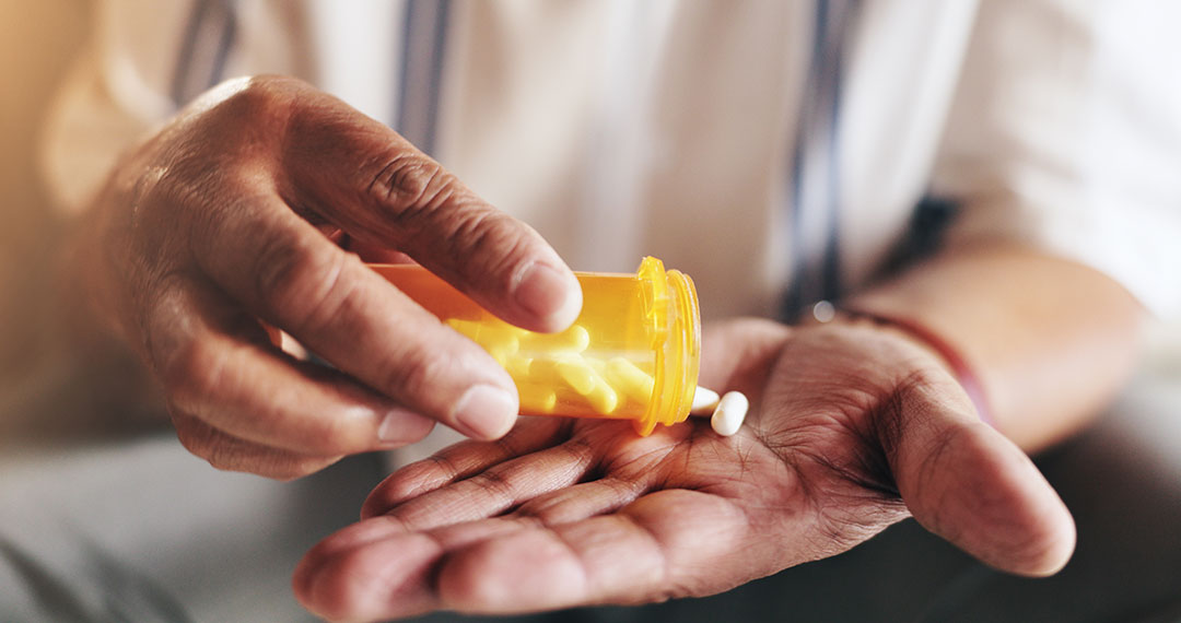 Hands, pills and bottle in closeup for person with antibiotics